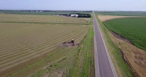 Aerial of Tractor and Rake next to Highway Stock Footage 221861564