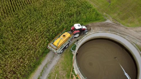 Aerial of a tractor leaving a slurry store after refilling the tanker Video stock 343515529