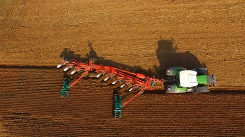 Aerial: Tractor plows a field in spring -Tractor cultivating a field in spring Stock Footage 88493918