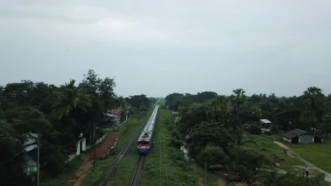 Aerial of a train approaching on tracks surrounded by green forest in Myanmar Stock Footage 95616445