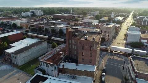 Aerial of Train Coming Through Small Town Video stock 115816395
