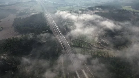 Aerial of Train Driving underneath Veil of Clouds 4k Drone Stock-Footage 294098796