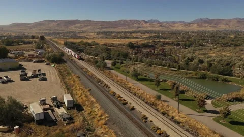 Aerial of train going through suburban town in western United States Vídeos de archivo 130667201