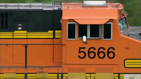 Aerial of train passing through the green landscape, Orange long goods train Stock Footage 109125064