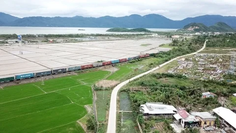 Aerial: train passing through rice fields in Vietnam Stock Footage 89350006