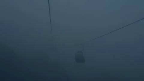The aerial tram goes down through a dense fog Stock Footage 301390846