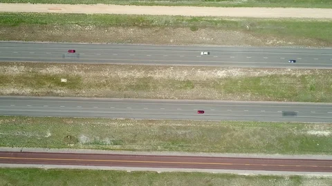 Aerial travelling shot of vehicles moving along highway in spring Stock Footage