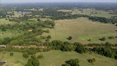 Aerial of trees and small pools on the green landscape on a sunny day Stock Footage 109121595