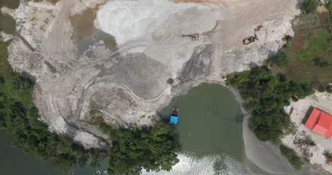 Aerial turning top-down sand dredging, pump barge, and excavators by a forest Stock Footage 331446982