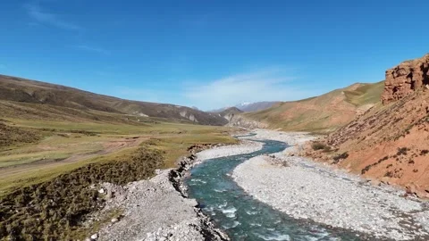 Aerial turquoise river cutting through colorful mountain valley in Xinjiang Stock Footage 337767280