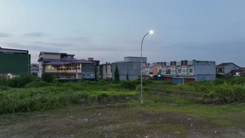 Aerial Twilight View of Empty Grass Lot and Urban Buildings 스톡 동영상 347261848