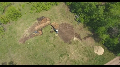 Aerial of two excavators doing earth works on digging house foundation pit Video stock 107654450