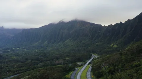 Aerial of two highways passing through tropical jungle, mountains in distance Stock Footage 126603955