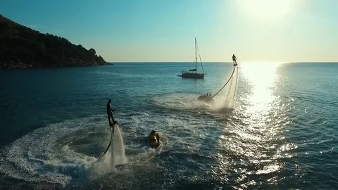 Aerial: Two men flying on flyboard at sunset. Stock Footage 70452492