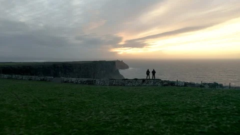 Aerial of Two Men Standing on the Cliffs of Moher, Ireland Stock Footage 123440790