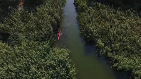 Aerial of two persons floating on small kayak in Dnipro basin with islets in Stock-Footage 146714210