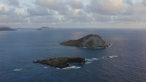 Aerial of two small islands in open sea with shore in distance, Hawaii Video stock 126604397