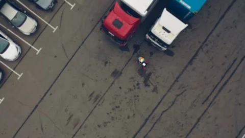 AERIAL. Two workers works on tablet near trucks. Camera zooming Stock Footage 111404563