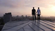 Aerial: Two Young Skateboarders Standing On Rooftop Stock Footage