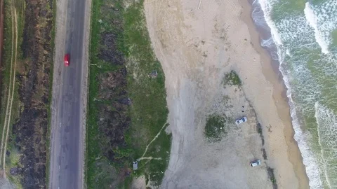 Aerial upside-down view of sea coast and cars on the beach Stock Footage 73813342