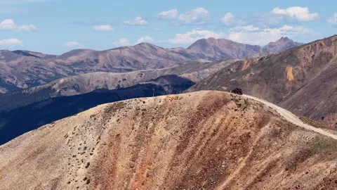 Aerial of UTV summiting Red Cone Pass on dirt road in Colorado four wheeling Stock Footage 343154736
