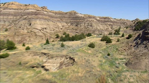 Aerial of valley between mountain ranges, Sharp jagged rocky landscape, road Stock Footage 109460548