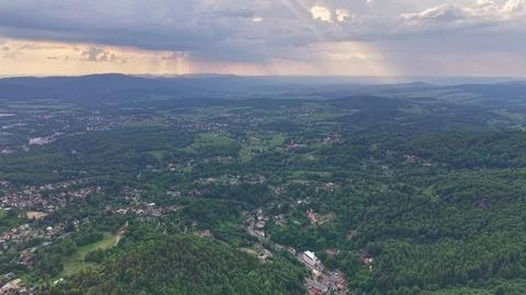 Aerial valley panorama over patchwork fields, forest, and distant mountains.. Stockfoto's