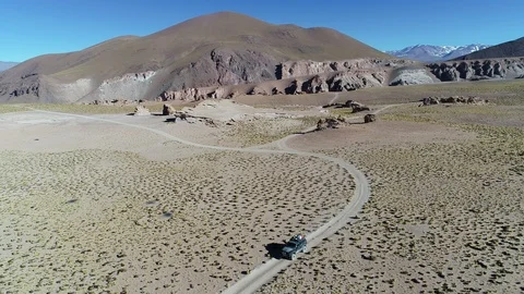 Aerial of van, front view, driving off road at high mountain, grasses and rocks 스톡 동영상 103447274