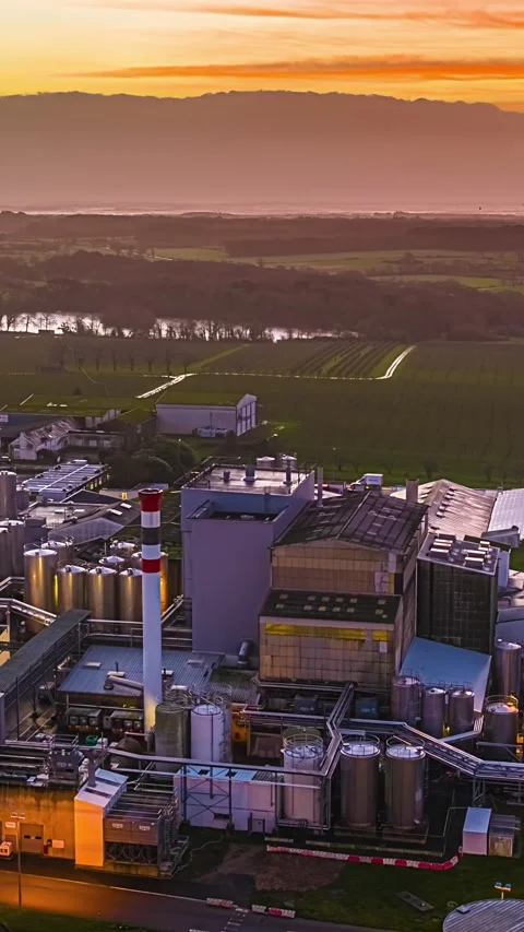 Aerial Vertical Hyperlapse Above Large Industrial Factory Complex at Sunset in Stock Footage 335343991