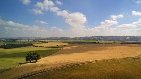 Aerial vertical reveal of fields, clouds and shadows moving across shot. Video stock 94077590