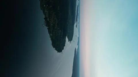 Aerial vertical shot from a camera flying over a wide river among forest Stock Footage 252310948