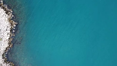 Aerial vertical shot of jetty with visible seabed and calm ripples Stock Footage 337462642