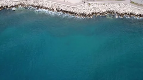 Aerial vertical shot of seaside path with people and crashing waves Stock Footage 337463242