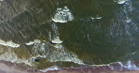 Aerial: Vertical spin from top to down. Below - seaside, waves and seagulls Stock Footage 81831929