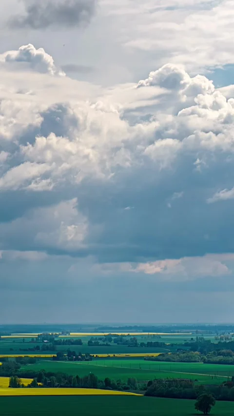 Aerial vertical timelapse of cumulus clouds moving above farmland fields in Stock Footage 337649395