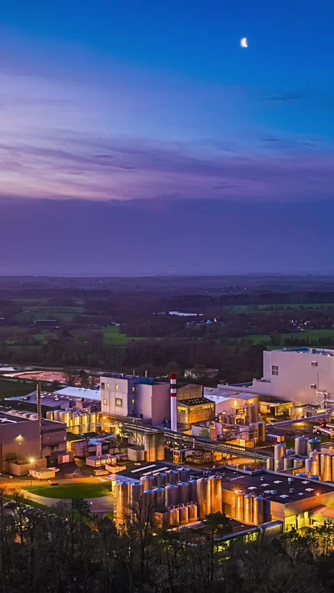 Aerial Vertical Timelapse of Illuminated Dairy Factory at Blue Hour Night with Stock Footage 335347191