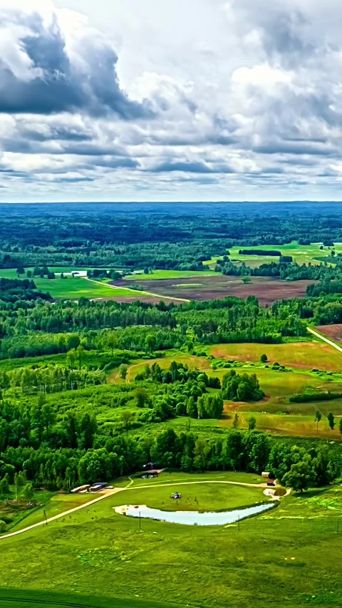 Aerial Vertical Timelapse Over Lush Green Latvian Countryside with Fields and Stock Footage 332957553