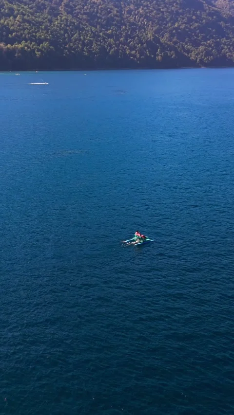 Aerial vertical tracking shot orbiting a person rowing a kayak on a vast de.. Stock Footage 339252224