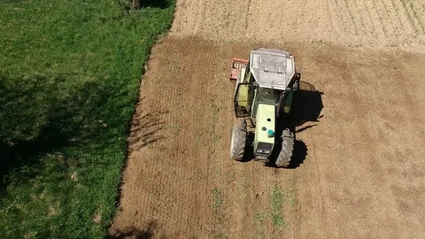 Aerial vertical tracking shot of tractor cultivating field for seeding Stock Footage 88818758