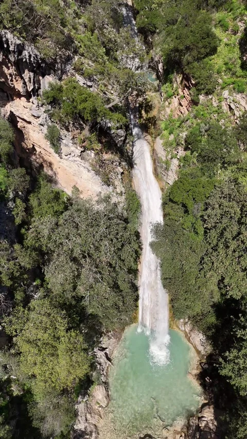 Aerial vertical View of Neda Waterfall and Emerald Pool on a Sunny Day, Greece Video stock 303995613