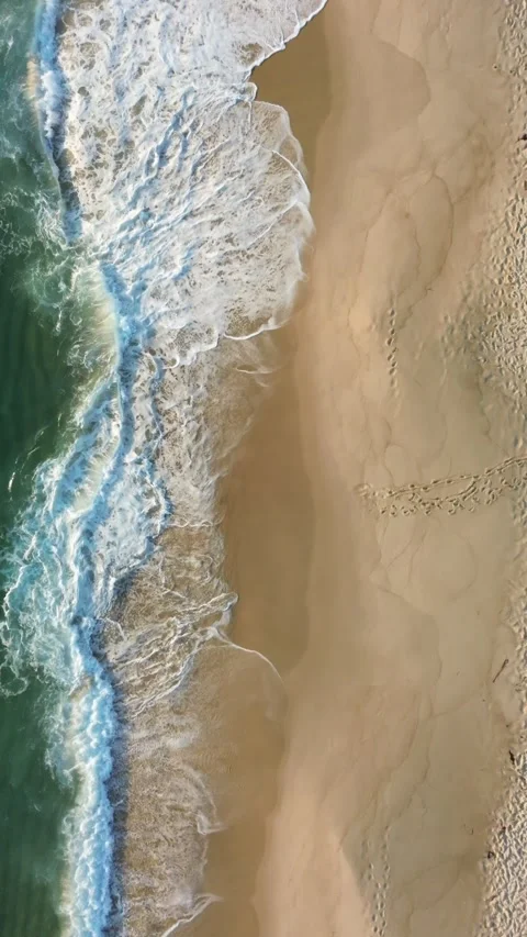 Aerial Vertical View of Ocean Waves Crashing on Sandy Beach at Sunset – 4K 库存影片 314616704