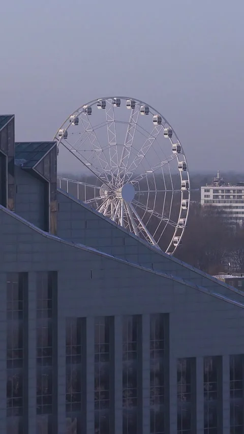 Aerial vertical view of Riga Ferris wheel behind modern building Vídeos de archivo 326819654