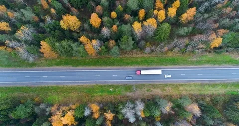 Aerial vertical view of the road in the fall. Overtaking a truck, car. 動画素材 96524301