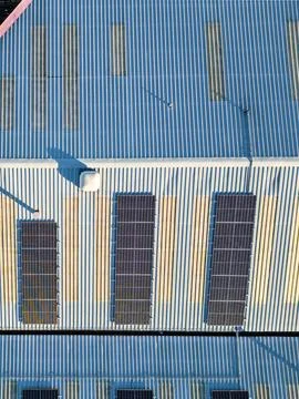 Aerial vertical view of solar panel photovoltaic cells on roof of factory, UK 写真素材