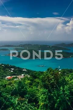 Aerial, vertical view on the turquoise sea and green hills around. Stock Photos