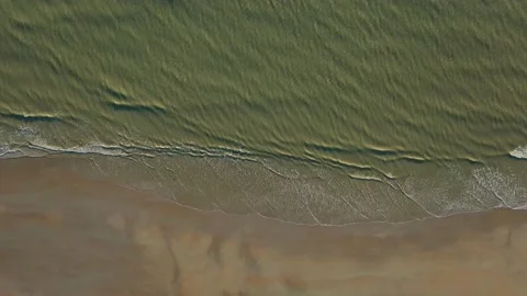 Aerial vertical view of waves ondulations splashing on sand beache Stock Footage 144552941