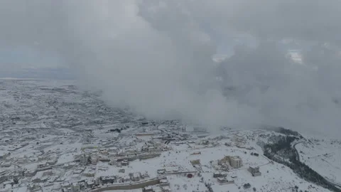 Aerial video between clouds of a snow-covered city in northern Israel Stock Footage 238686786