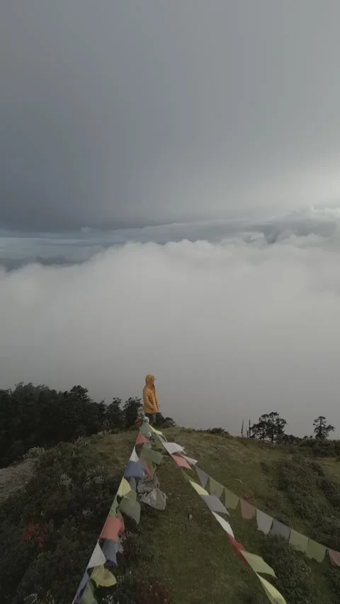 Aerial video of clouds in the background a man standing on a peak in Nepal Stock Footage 261620484