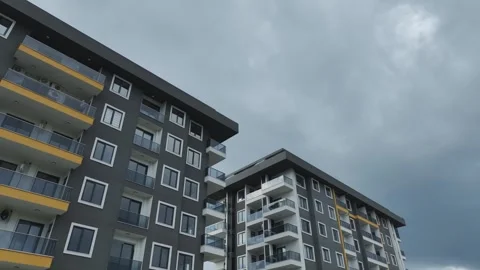 Aerial Video Dramatic Cloudy Sky Frames the Facade of a Contemporary Building Stock Footage 301002227