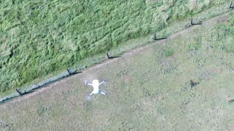 Aerial video from a drone of another drone seen hovering directly from above Stock Footage 159644822